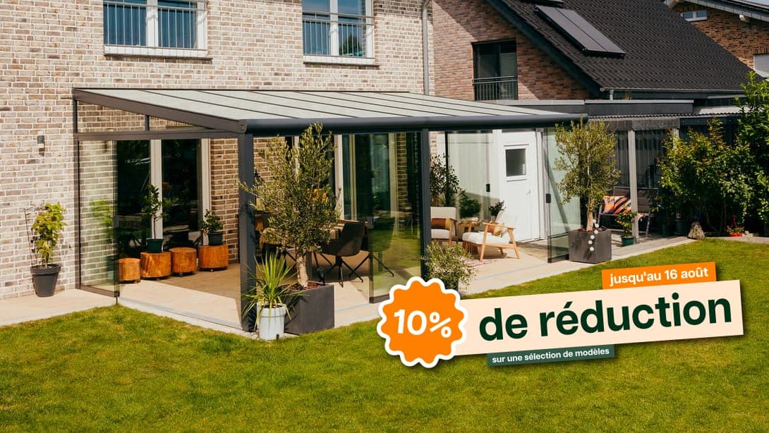 Véranda avec parois coulissantes en verre et éclairage d'ambiance Terrasoverkapping aan een woning bij zonsondergang, met een stel dat ontspannen op een comfortabele bank zit.Véranda avec parois coulissantes en verre et éclairage d'ambiance
