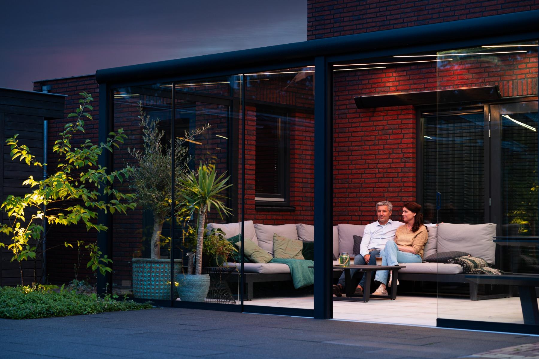 Mat zwarte terrasoverkapping met Gumax® Lighting sytem en glazen schuifwanden